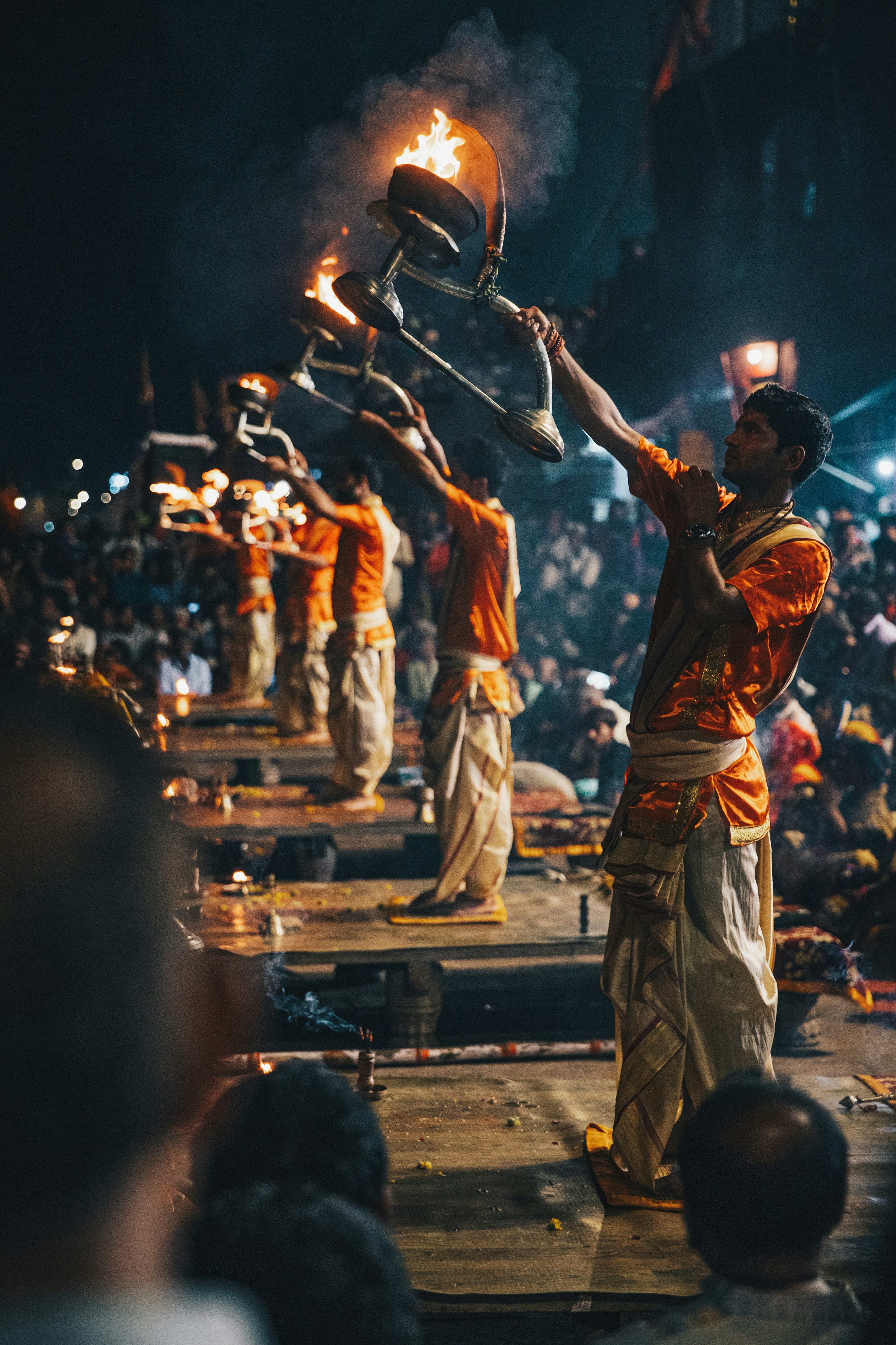 Priests raising ceremonial lamps during the evening Ganga Aarti in Varanasi